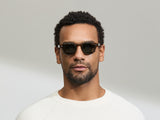 Model trägt Moscot Cliptosh in Größe 46, Farbe Schwarz Matt, G-15 polarisiert