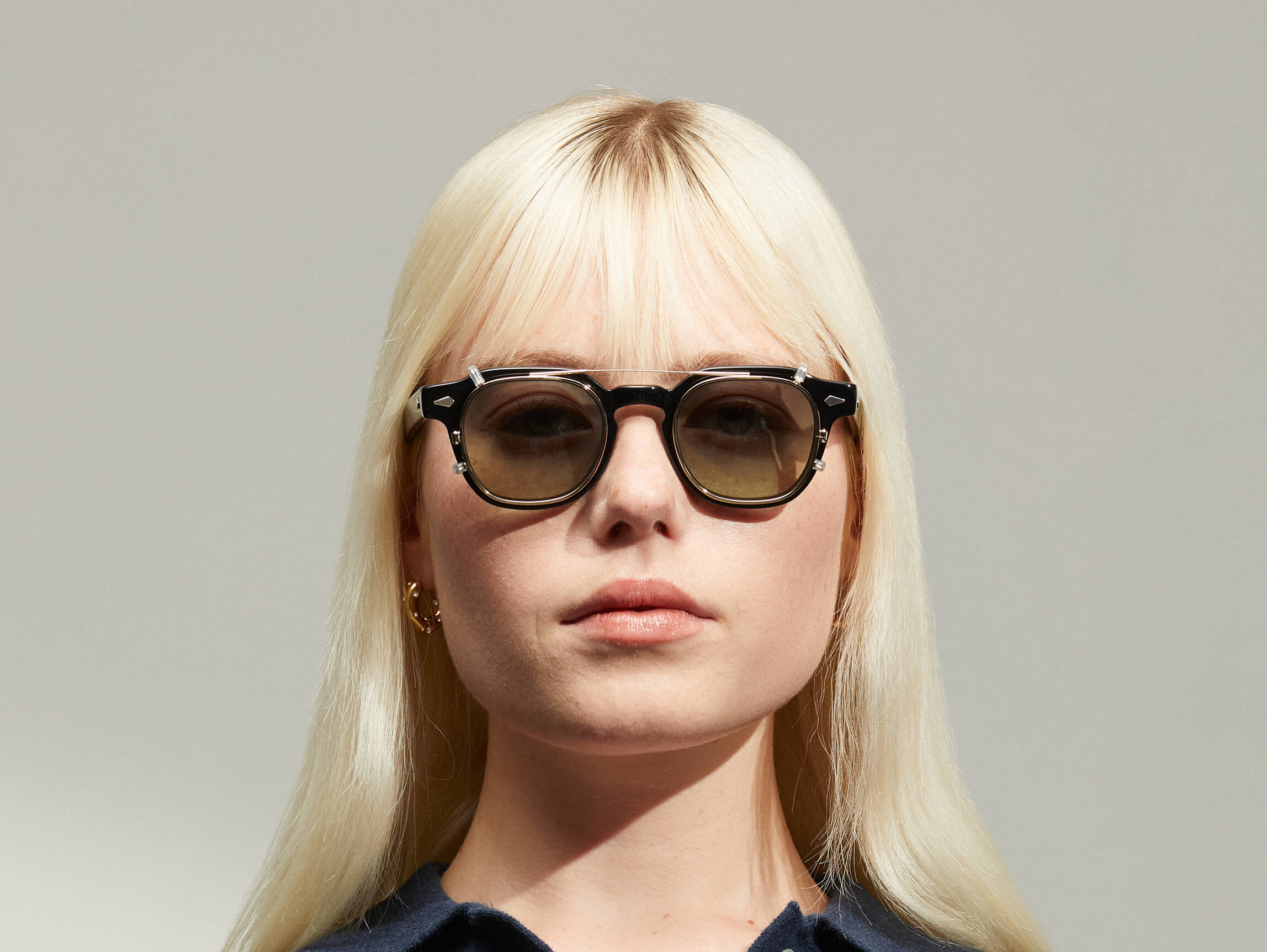 Model trägt Moscot Dolt Clip in Größe 46, Farbe Gold, Tönung Forest Wood