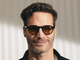 Model trägt Moscot Miltzen in Größe 46, Farbe Black, Tönung Amber