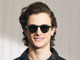 Model trägt Moscot Miltzen Sun in Größe 46, Farbe Emerald, graue Gläser